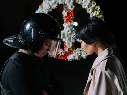 A military man stands with a woman looking down in a moment of silence