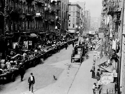 Mulberry Street in New York City's Little Italy crowded with vendors, horse-drawn carts, and residents during the neighborhood's vibrant immigrant era