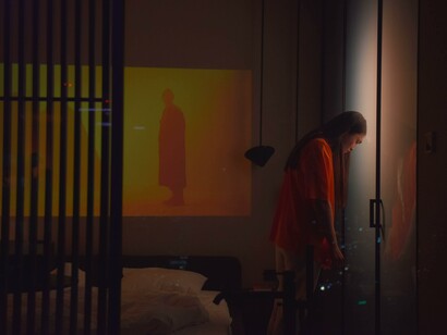 A woman standing in her bedroom in the middle of the night, suffering from insomnia