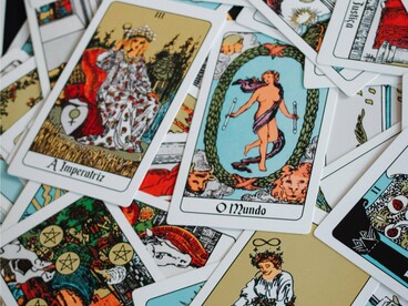 Um conjunto de cartas de tarot coloridas organizado para uma leitura. Mais do que prever acontecimentos, o artigo convida a refletir sobre o equilíbrio entre autoconhecimento e autonomia diante das interpretações