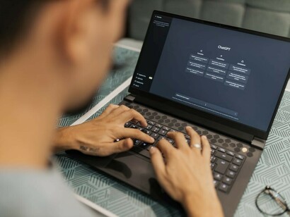 A man using his computer to engage in a conversation with ChatGPT, interacting with the AI chatbot