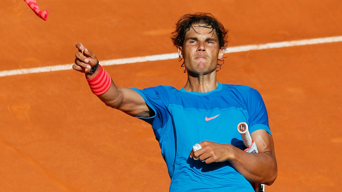 El tenista Rafael Nadal regala sus muñequeras al público tras terminar un partido