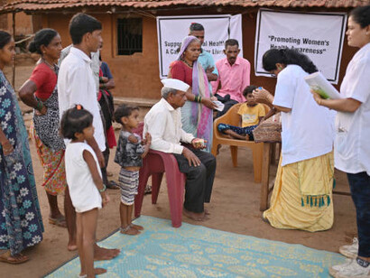 In a rural medical camp in India, a female doctor educates women on healthcare, tackling issues like public health advocacy, health inequities, and the influence of neoliberalism on health, while championing social justice and human rights in the fight for equitable healthcare