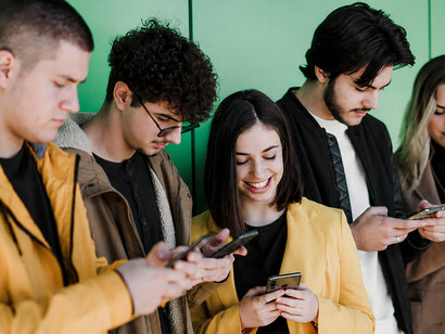 Young adults are absorbed in their smartphones, sharing the same space but not engaging in conversation