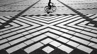 Un niño en bicicleta en una plaza desierta