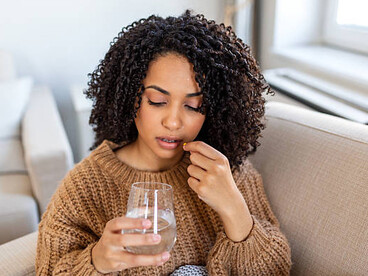 A young woman takes a daily supplement to help support her knee joints and mobility