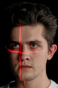 Portrait of a man with laser lines on his face, symbolizing facial recognition technology