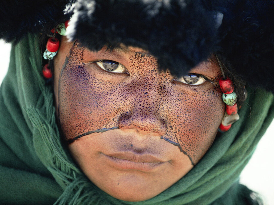 Kazuyoshi Nomachi, Tibet, Una ragazza nomade con il volto cosparso di una sostanza protettiva durante un pellegrinaggio, Tibet, Cina 1990 © Kazuyoshi Nomachi
