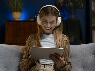 A woman streaming content on a tablet, reflecting how platforms gather insights from everyday user interactions
