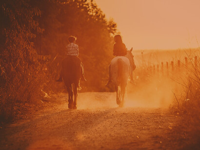Mientras el día llega a su fin, dos niños cabalgan hacia la puesta de sol. No te preocupes, he puesto los caballos en el establo y hay una ensillado esperando por ti