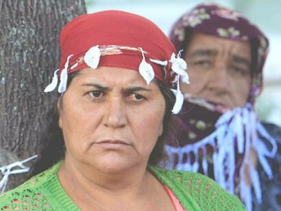 A concerned look on an older woman from the Roma group