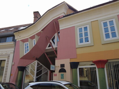 The building named Munkácsy Udvar was designed by Sándor Dévényi along with Endre Borza and Kristóf Lápossy. The stone walls on the ground floor evoke the medieval residential building that once stood on this site, the remains of which are still visible in the redesigned basement created for this purpose. Pécs, Hungary