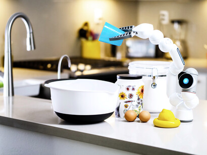 A kitchen robot, an example of AI, pours liquid into a bowl