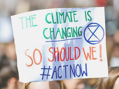 A person holds a sign that reads, "The climate is changing" in  Lorenzer Platz, Nuremberg, Germany