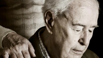 Una mujer anciana apoya su mano sobre el hombro de su marido