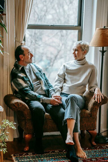 A happy couple sharing a warm conversation while resting on a couch