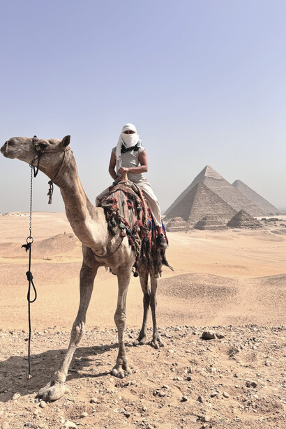 Riding a camel against the breathtaking backdrop of the majestic Giza Pyramids, Egypt