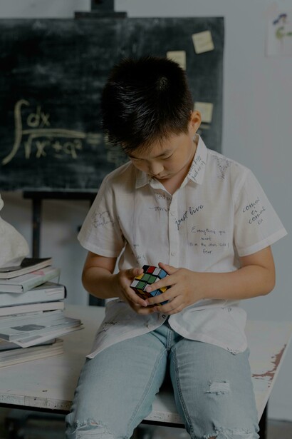 Um menino resolvendo um cubo de Rubik