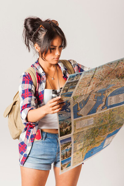 A woman studies a map carefully, her brow furrowed in concentration as she plots her journey ahead