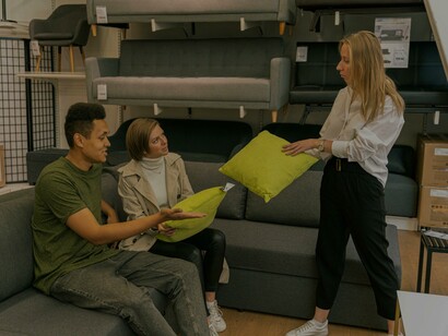 Clientes experimentam sofá e almofadas na loja