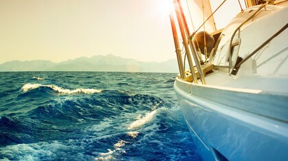 Un barco velero navegando frente a la costa