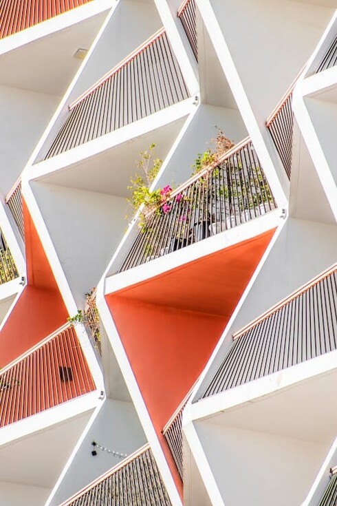 A sleek, minimalist-style orange building with simple balconies, located in Dubai, United Arab Emirates