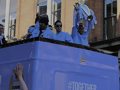 Gael Clichy lifts the Premier League trophy during Manchester City's celebratory open-top bus tour of Manchester on 14 May 2012