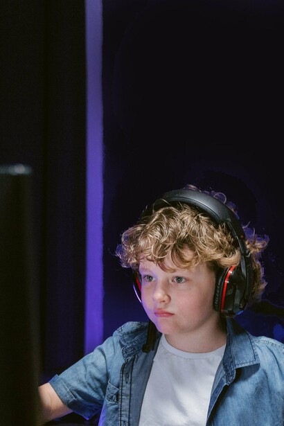 Young boy listening to headphones and looking at computer