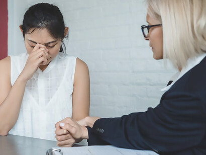 In an empathetic therapeutic session, a woman in distress seeks solace and support from her psychotherapist