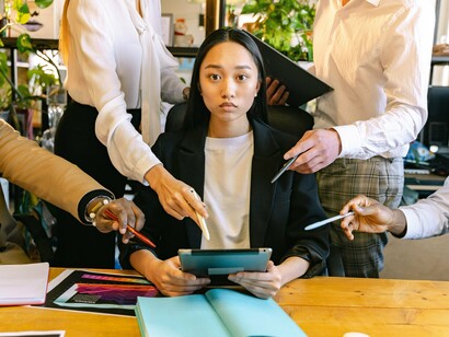 A professional stressed out by having too many people in her space, symbolising the balance between collaboration and workplace pressure