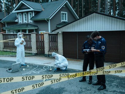 Forensic investigators reviewing evidence together at an active crime scene
