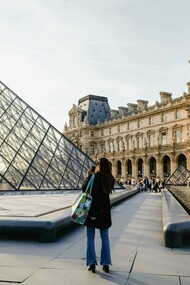 A woman photographs a building in Paris, Île-de-France, France
