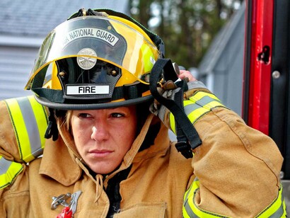 A woman firefighter getting ready to suit up and tackle the chaos in her hopes to keep the peace