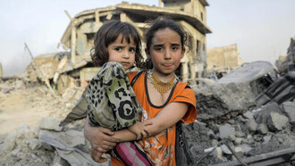 Niñas sirias frente a los escombros dejados por la guerra