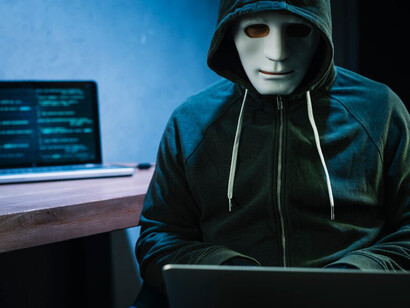 The image of a hacker with a laptop illustrates the urgent challenges of data privacy and the widespread implications of data collection practices