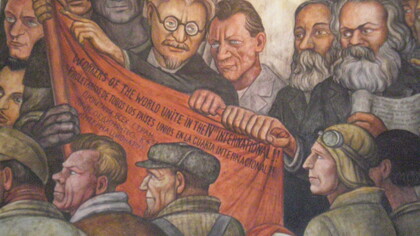 Fragmento de «El hombre controlador del Universo», mural de Diego Rivera en el Palacio de Bellas Artes de México: sostienen la bandera Trotski (en el centro), Engels y Marx (derecha)