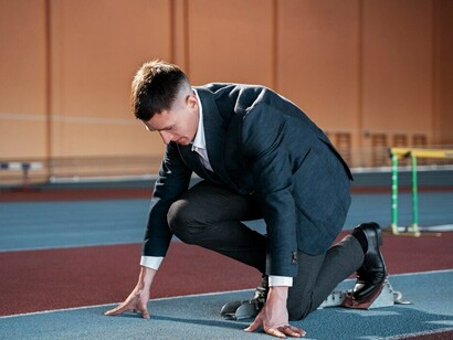 A fit man in a suit, ready to run, symbolizes the coaching journey, business hustle, and the entrepreneurial struggle—preparing to face the challenges and put in the work needed to reach success