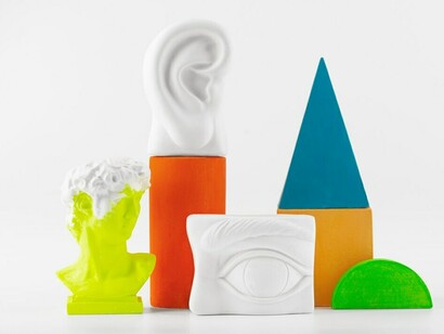 Vividly colored still-life arrangements of small decorative objects symbolize sensory overlap, neural connections, and the complex interplay between the brain and senses