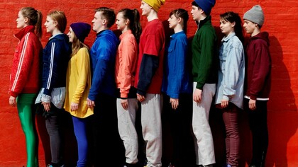 Fila de jóvenes Millenials junto a un muro