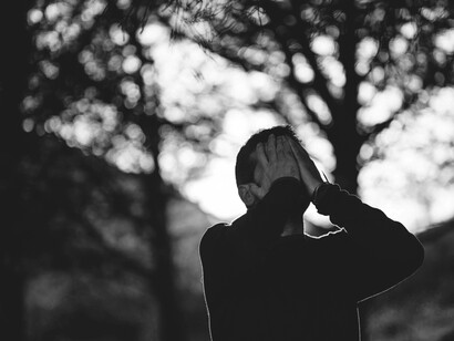 A man once filled with happiness is now covering his face with sadness and gloom