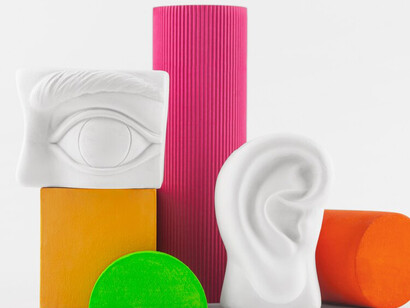 A still life of small decorative objects with vivid colors represents colorful visualizations, sensory overlap, neural connections, and the intricate relationship between the brain and senses