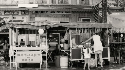 Mãe faz compras com a filha em um mercado nas ruas da França