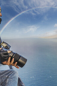 Donn Delson photographing rainbow from a helicopter  