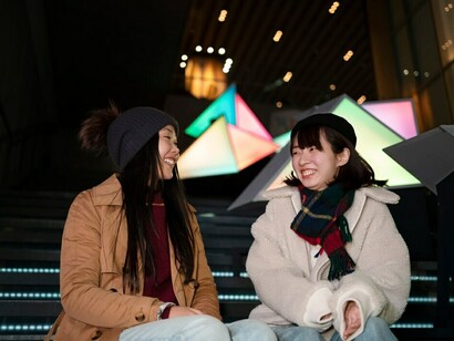 Friends share a lighthearted moment, smiling and enjoying each other's company as they stroll through the bustling city of South Korea