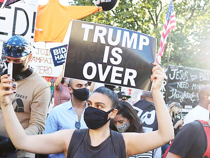 On the streets after Trump's defeat, 2020 people carrying 'Trump is Over' banners