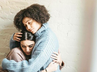Two friends hugging each other after they experienced a difficult situation 