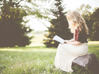 Mujer leyendo rodeada de naturaleza