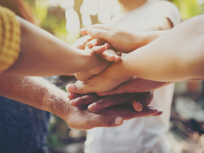 A team joining hands in unity and collective action, symbolizing the human struggle for peace