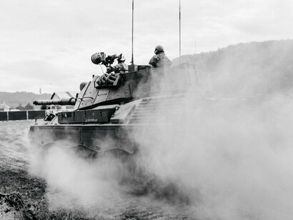 An army tank chugs along leaving dust and mayhem behind them in these war times caused by Russian President Vladimir Putin