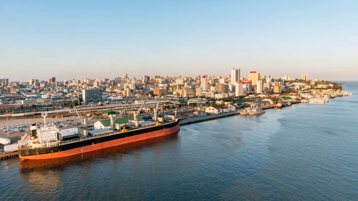 Vista panorâmica do porto de Maputo, com o horizonte urbano e as águas da baía em destaque. A dinâmica econômica moçambicana exige que as empresas adotem métodos quantitativos para controlar custos e tomar decisões mais precisas em ambientes de constante transformação